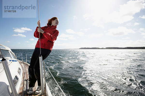 Young Woman holding auf Seil auf yacht