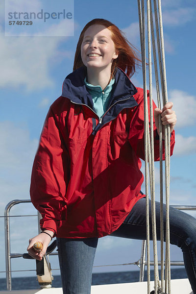 Young Woman holding auf Seil auf yacht