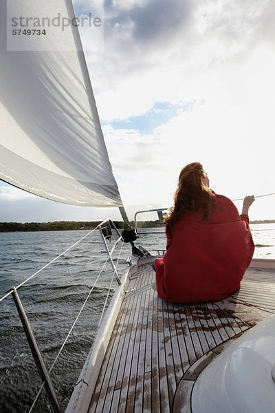 Frau am Bug der Yacht sitzend