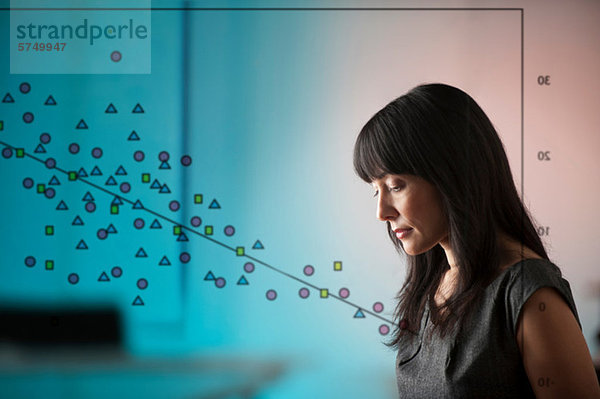 Reife Frau mit Formendiagramm am Fenster