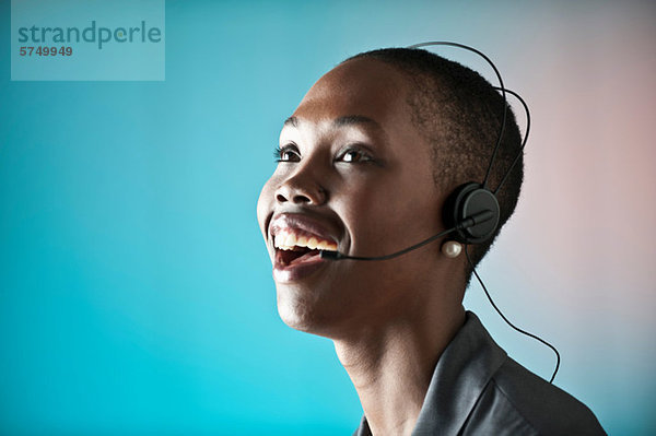 Junge Frau mit Telefon-Headset  lachend