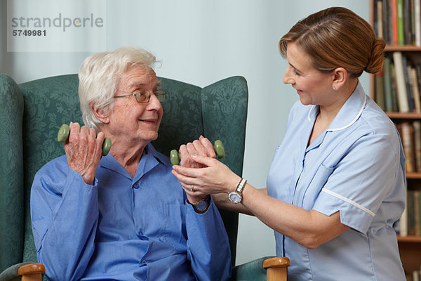Betreuerin mit Handgewichten für Senioren