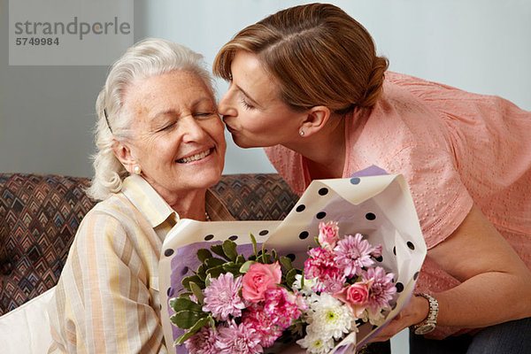 Tochter schenkt Senior-Mutter Blumenstrauß