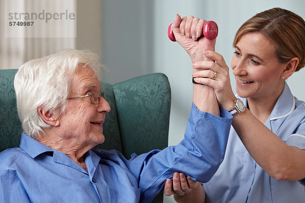 Betreuerin mit Handgewichten für Senioren
