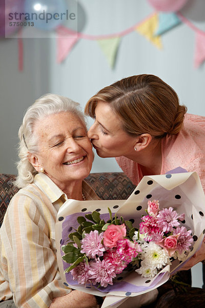 Tochter schenkt Senior-Mutter Blumenstrauß