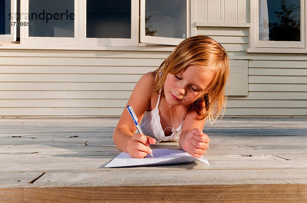 Girl on porch  drawing a picture