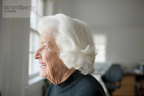 Porträt einer älteren Frau mit Blick aus dem Fenster