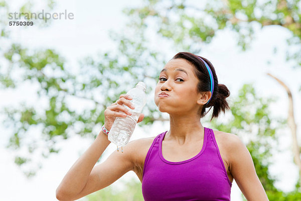 Junge Frau trinkt Mineralwasser