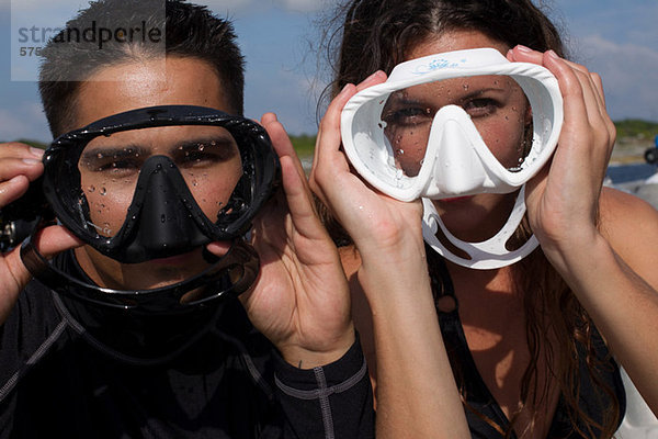 Verspieltes Paar mit Gesichtsmasken