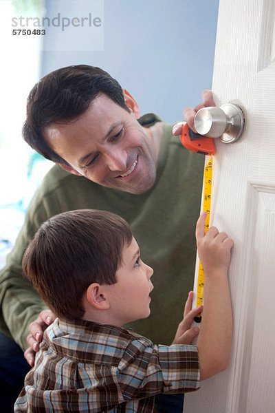 Vater und Sohn messen Tür zu Hause