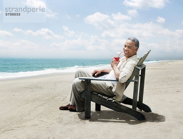 Älterer Mann entspannenden Stuhl am Strand
