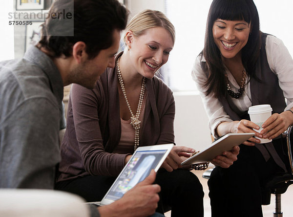 Kollegen  die digitale Tabletts in Meetings verwenden