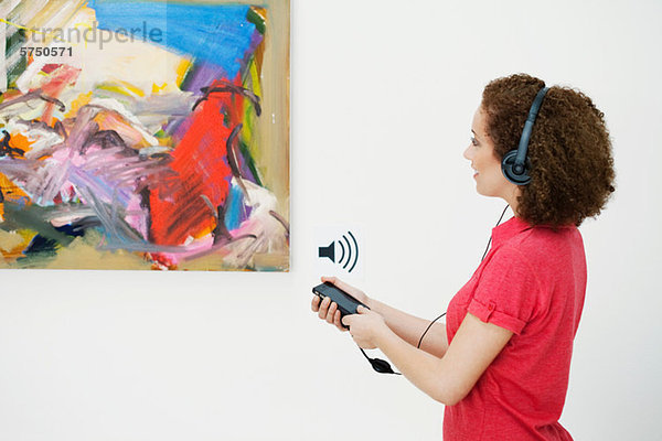 Junge Frau mit Audioguide in der Kunstgalerie