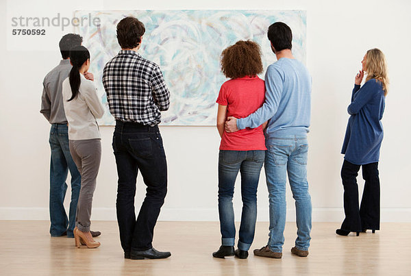 Männer und Frauen beim Betrachten der Ölmalerei in der Kunstgalerie