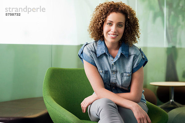 Portrait of young Woman sitting in grünen Stuhl im Büro