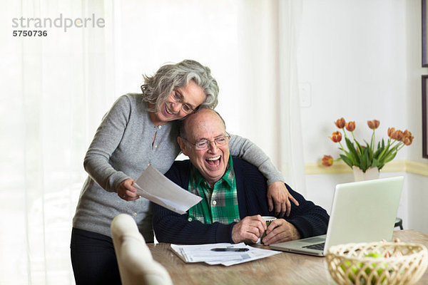 Senior Senioren benutzen Notebook lachen Wohnhaus