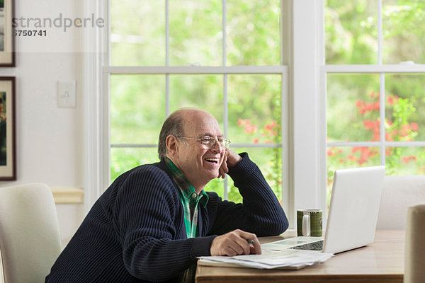 Senior Senioren benutzen Mann Notebook lächeln Wohnhaus