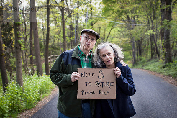Seniorenpaar mit Schild im Wald  Portrait