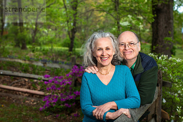 Seniorenpaar im Wald sitzend  lächelnd  Portrait