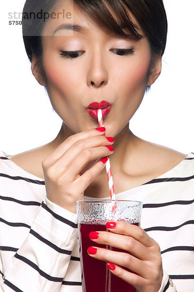 Young Woman drinking aus Stroh against white background