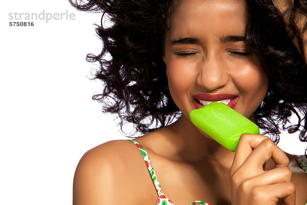 Young Woman eating grün Popsicle mit Augen geschlossen