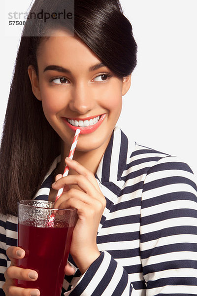 Junge Frau im gestreiften oberen Trinkwasser aus Stroh against white background