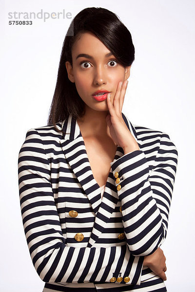 Junge Frau in striped Top suchen schockiert vor weißem Hintergrund