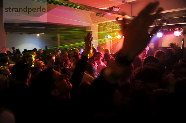 Viele Jugendliche auf der Tanzfläche in einer Diskothek halten die Hände in die Höhe
