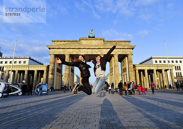 Freudensprung  zwei Mädchen springen vor dem Brandenburger Tor in die Luft  Berlin  Deutschland  Europa