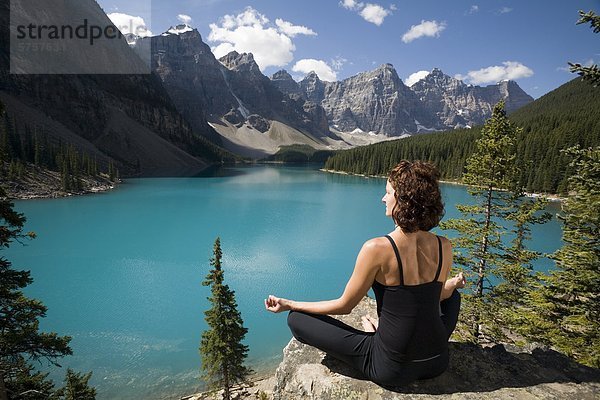 Eine Frau Praticing Meditation  Moraine Lake  Banff Nationalpark  Alberta  Kanada.
