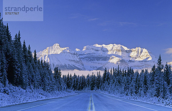 Icefields Parkway und die sonnenbeschienene Berge über dem Lake Louise nach einer frischen Schneedecke  Banff Nationalpark  Alberta  Kanada.