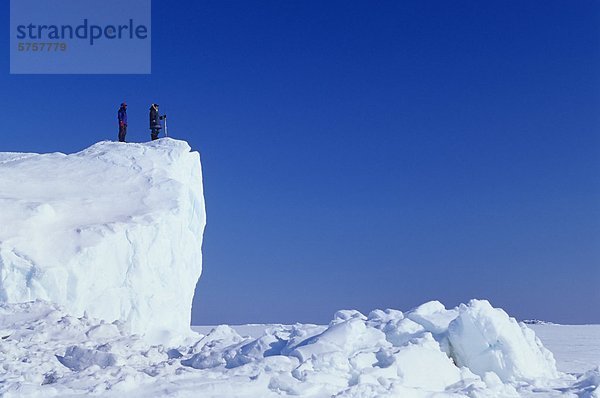 Inuit-Führer und Client auf Eisberg eingefroren im Meereis  Kimmirut  Baffininsel  Nunavut  Kanada.