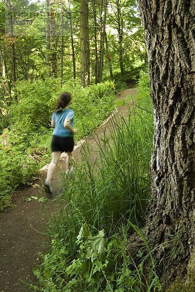 Junge Frau Trail-Läufer in der Witty Lagune Regional Park in der Nähe von Victoria  Vancouver Island  British Columbia  Kanada.