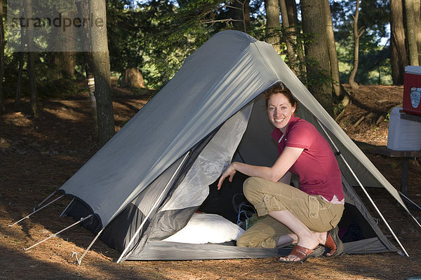 Eine junge Frau betritt ihr Zelt bei einem camping-Ausflug  Oasler Lake Provincial Park  Ontario  Kanada.