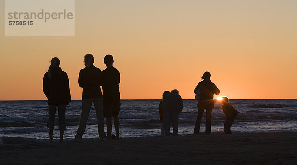 Eine Familie wacht den Sonnenuntergang über den Huronsee in Sauble Beach  Ontario  Kanada.