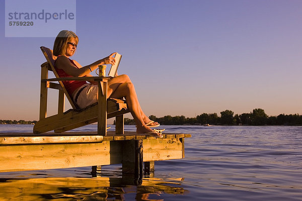 Frau entspannend auf Dock am See. Alberta  Kanada.