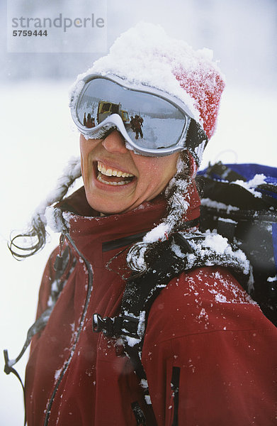 Eine glückliche Frau Skifahrerin lachend mit Schnee auf dem Kopf nach einem großen Tag der Katze-Skifahren im Wildhorse Creek  nahe Selkirkgebirge Nelson  British Columbia  Kanada.