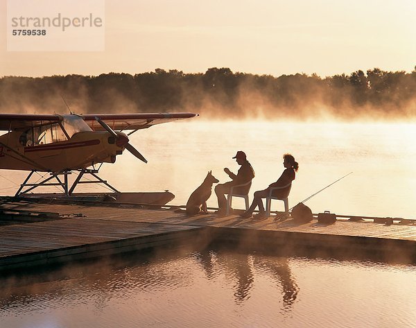 paar auf Dock im frühen Morgennebel  am Red River  nördlich von Selkirk  Manitoba  Kanada.
