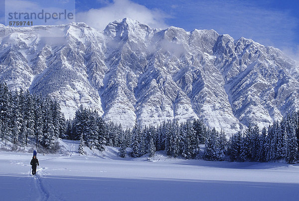 Eine junge Mand Schneeschuhwandern über einen See erreicht man eine epische Hinterland Ski-Destination  Kananaskis Country  Alberta  Kanada