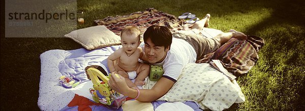 38 Jahre alten asiatischen Männchen mit eurasischen Baby auf dem Rasen in den Hof in der Hütte  Knowlton  Québec  Kanada.