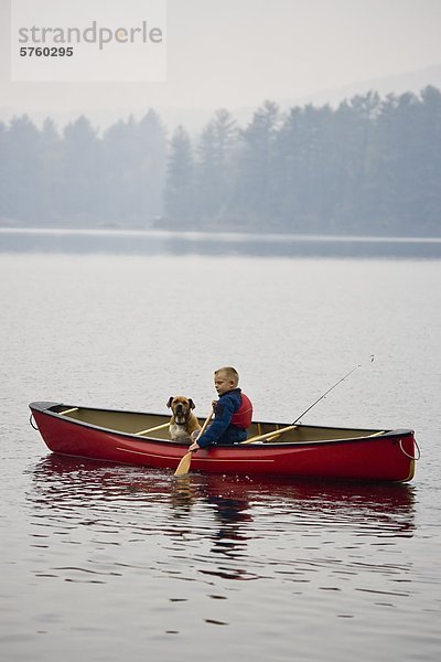 Kleiner Junge geht Angeln mit Hund im Kanu Quelle See  Algonquin Provincial Park  Ontario  Kanada.