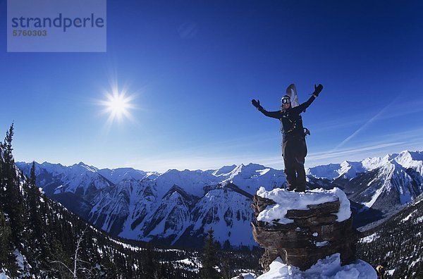 Snowboarder stehen auf Felsen mit Blick auf die Bergkette im Hinterland von Alberta  Kanada.