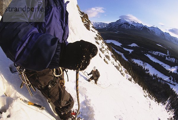 Ein Eiskletterer Sicherung seiner Partnerin auf Kaskade fällt WI 3  Banff Nationalpark  Alberta  Kanada