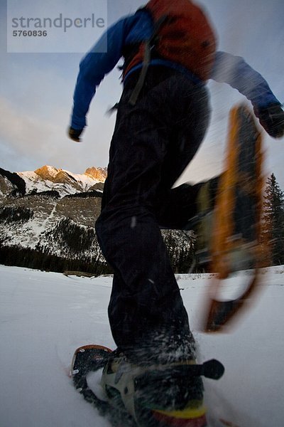 Ein Schneeschuhwanderer genießen am frühen Morgen laufen auf Lake Minnewanka  Banff Nationalpark  Alberta  Kanada