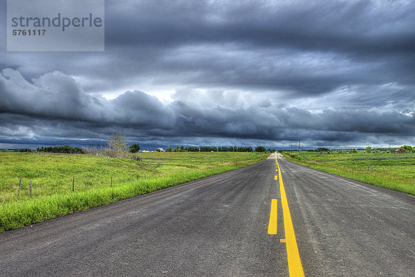Land-Autobahn und Gewitterwolken in der Nähe von Cochrane  Alberta  Kanada