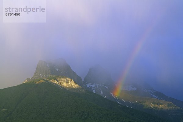 Ein Regenbogen in einem dramatischen Gewitter über die drei Schwestern Berge  Canmore  Alberta  Kanada