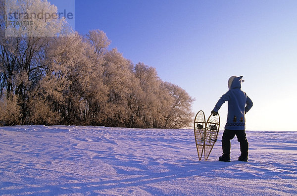 Mann mit Schneeschuhen Blick auf Bäumen bedeckt mit Raureif  in der Nähe von Dugald  Manitoba  Kanada