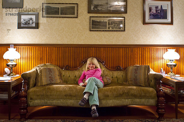 Fünf Jahre altes Mädchen auf Antik Sofa. Quilchena Hotel  British Columbia  Kanada.
