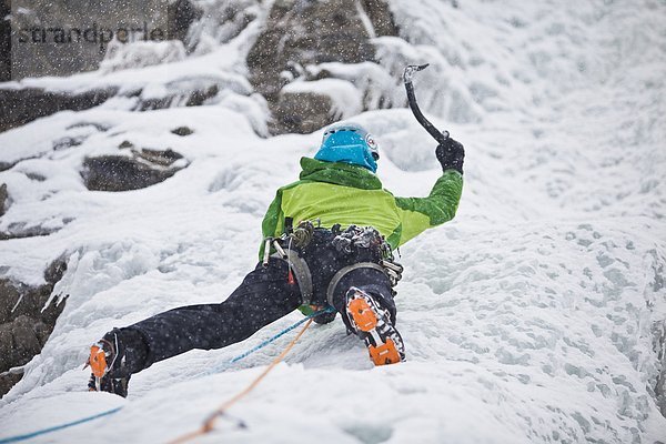 Eine starke weibliche Kletterer Eis klettert Moonlight WI4  auch Thomas Creek  Kananaskis  Alberta  Kanada