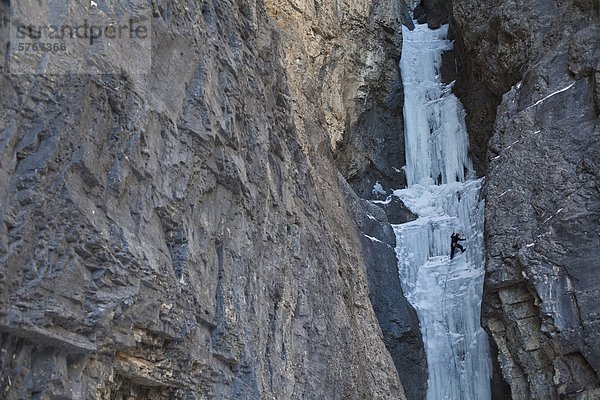 Ein Mann mittleren Alter Climbc Aquarius WI4  in der schönen Ghost River Valley in Alberta  Kanada